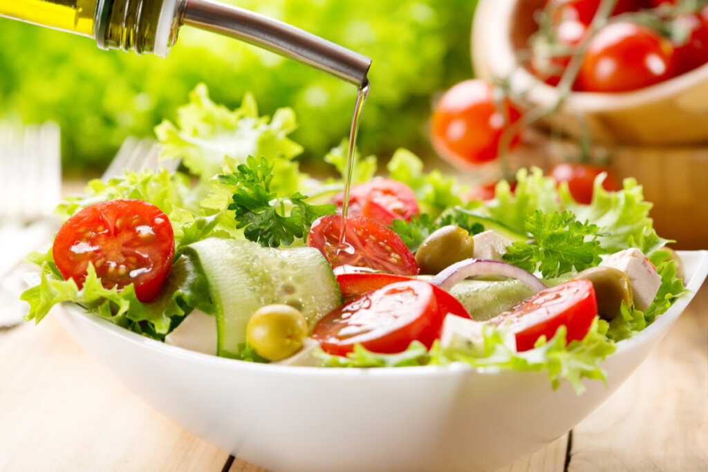 Salada com alface, tomate, pepino, azeitonas e azeite dentro do bowl branco