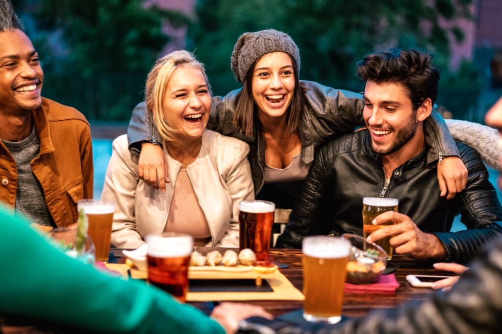 Pessoas feliz ao redor de uma mesa tomando cerveja