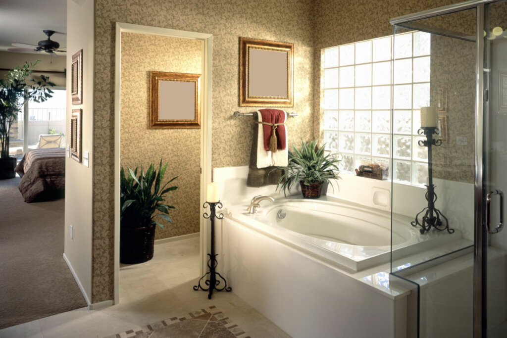Banheiro comm banheira branca, parede com papel de parede e vasos de planta