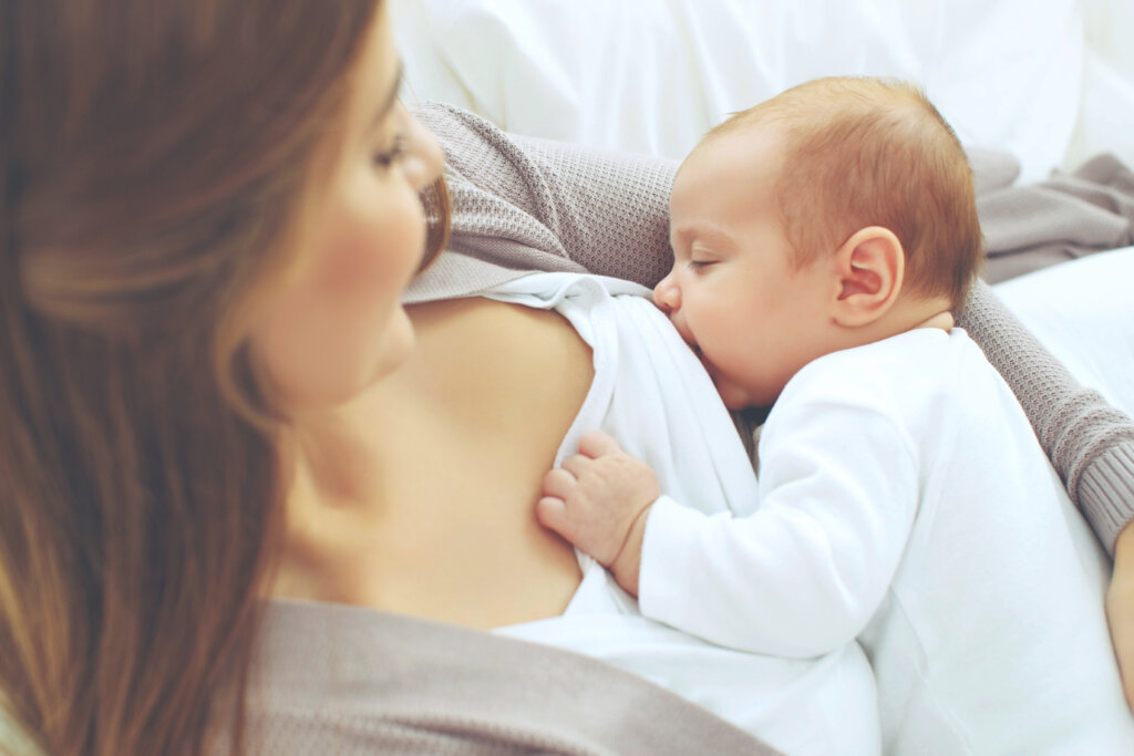 Bebê no colo de uma mulher mamando 