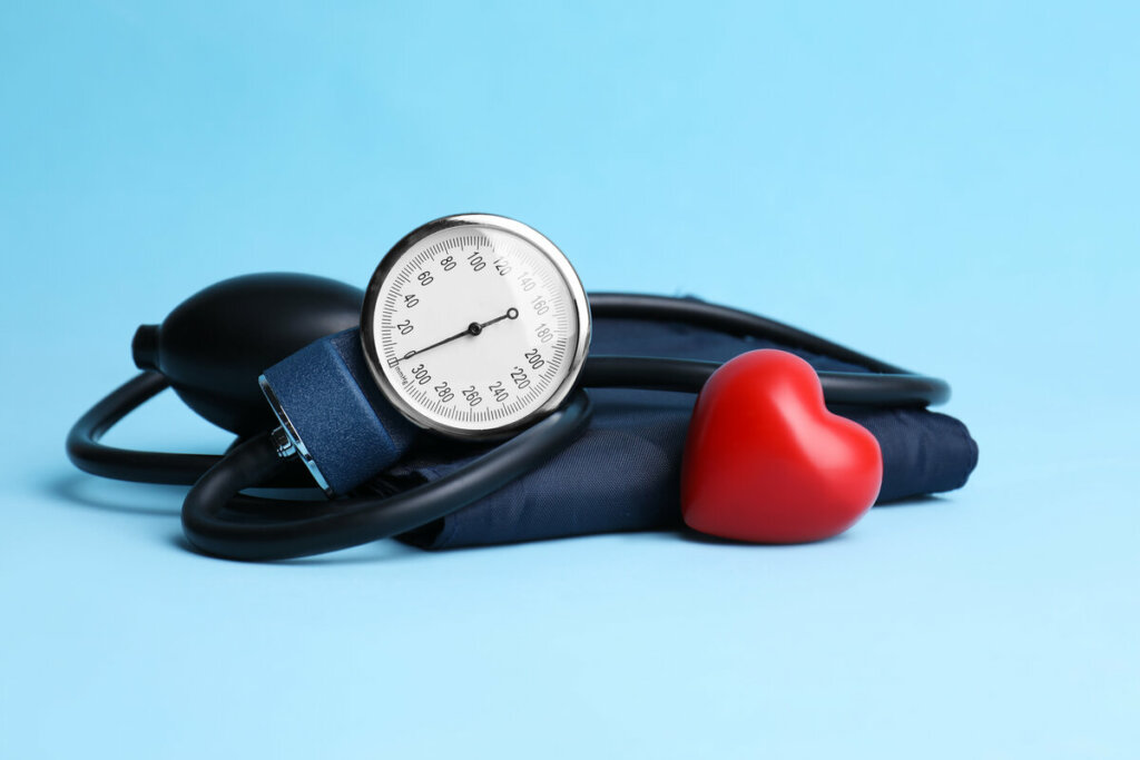 Medidor de pressão arterial ao lado de um coração de plástico