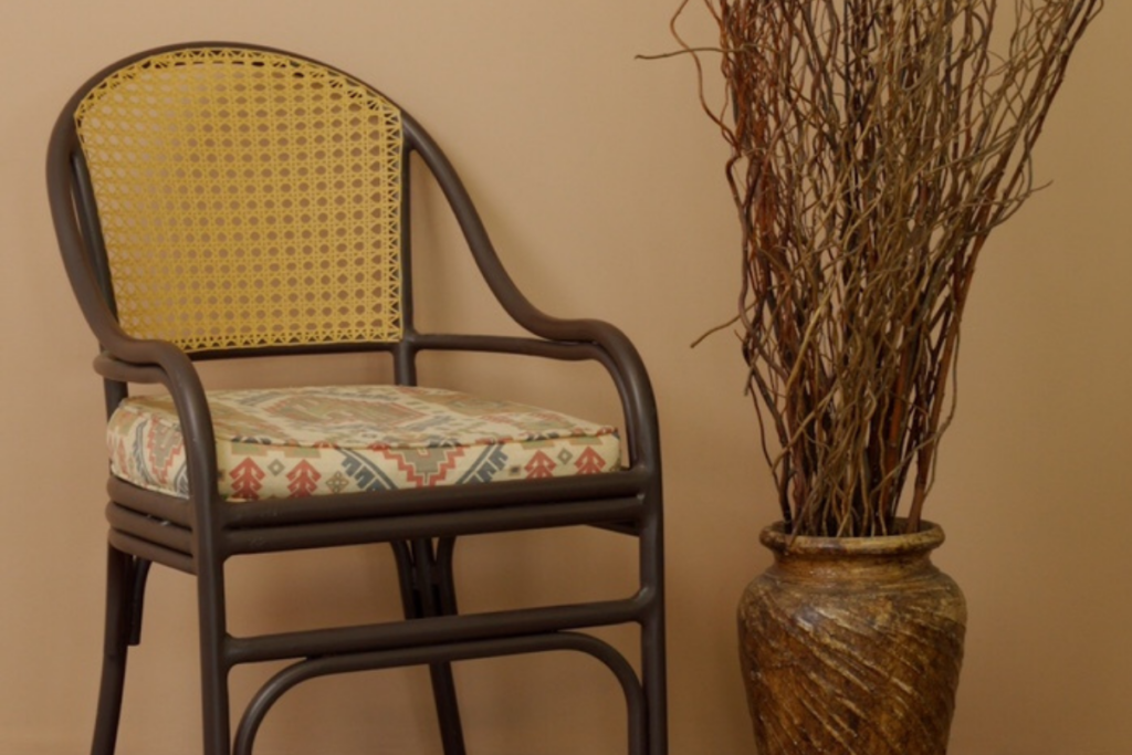 Sala de estar com parede bege, cadeira e vaso de planta marrons 