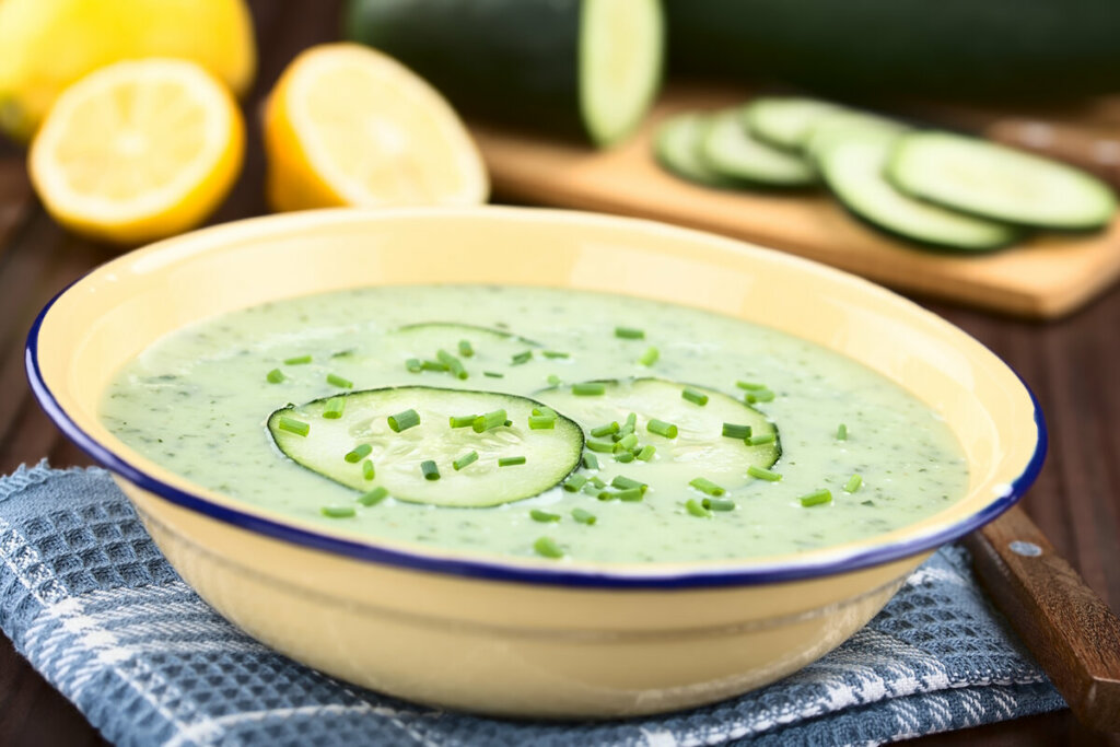 Sopa de pepino decorada com fatias de pepino e salsinha picada