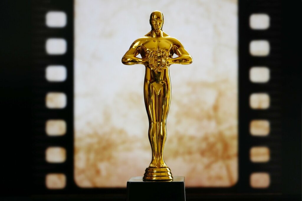 Estátua do Oscar em frente a um fundo dourado
