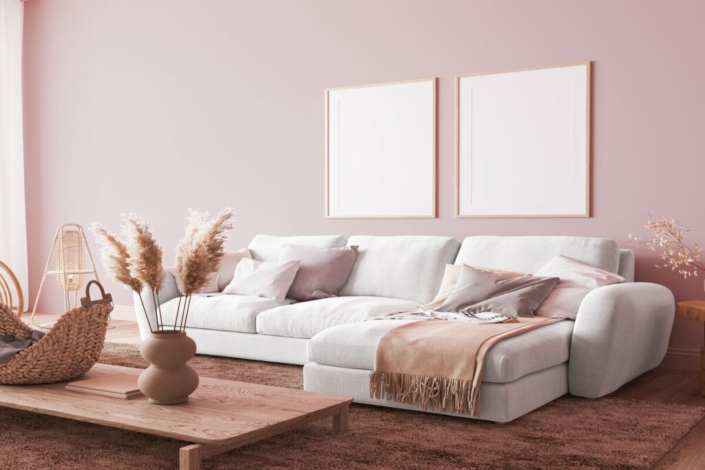 Sala de estar com sofá branco e parede rosa