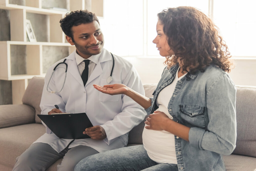Médico conversando com uma mulher grávida