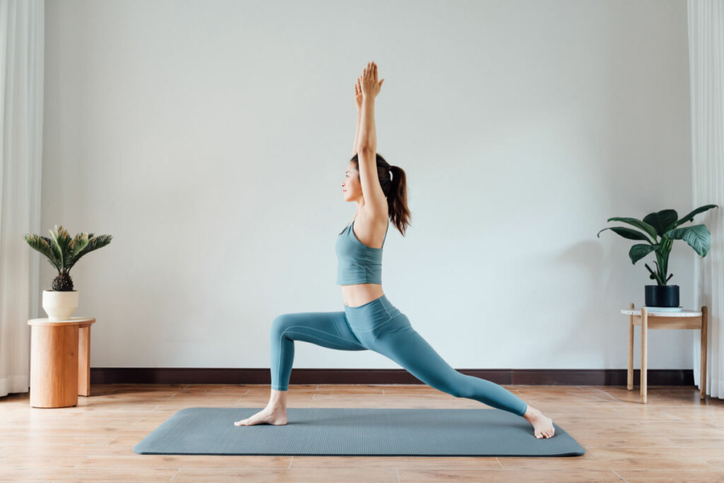 Mulher fazendo postura em pé no tapete de yoga