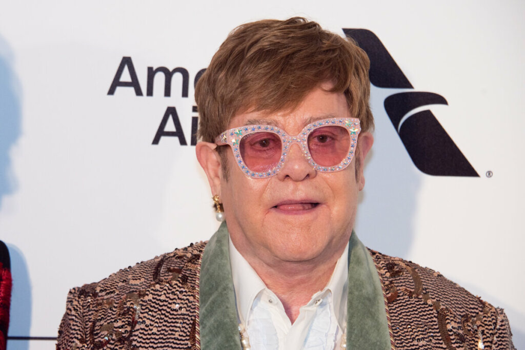 Elton John usando óculos com brilhos 