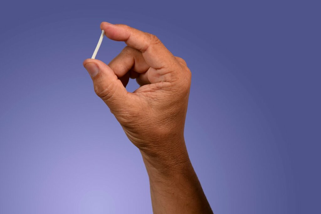 Uma mão segurando chip anticoncepcional