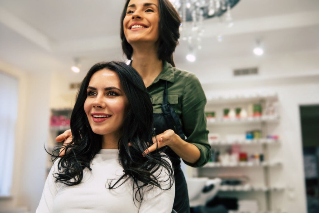 Cabeleireira mostrando o corte novo de cabelo da cliente