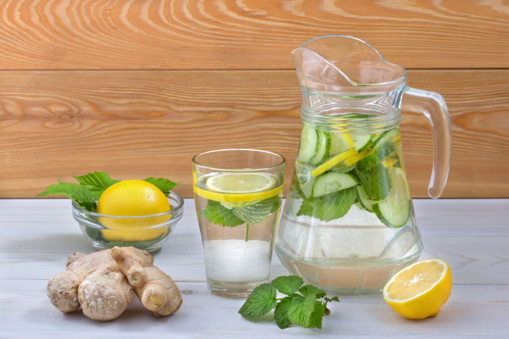 Jarra de suco água aromatizada com folha, limão-siciliano, copo e pote com os mesmos itens 