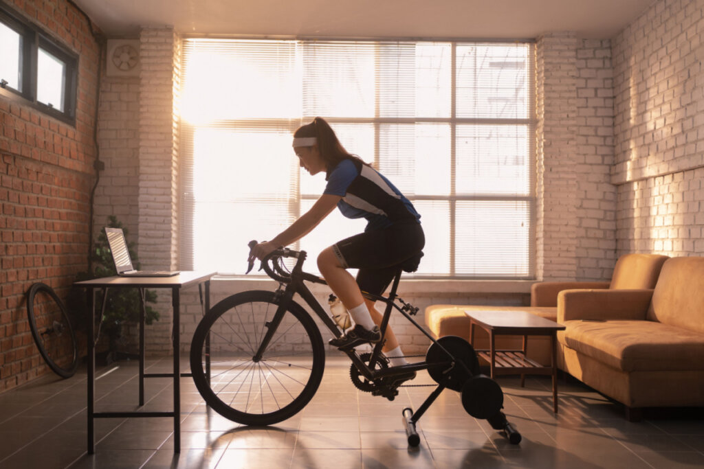 Mulher ciclista se exercitando em casa