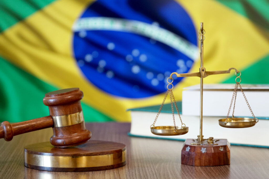 martelo e balança da justiça no fundo da bandeira do brasil