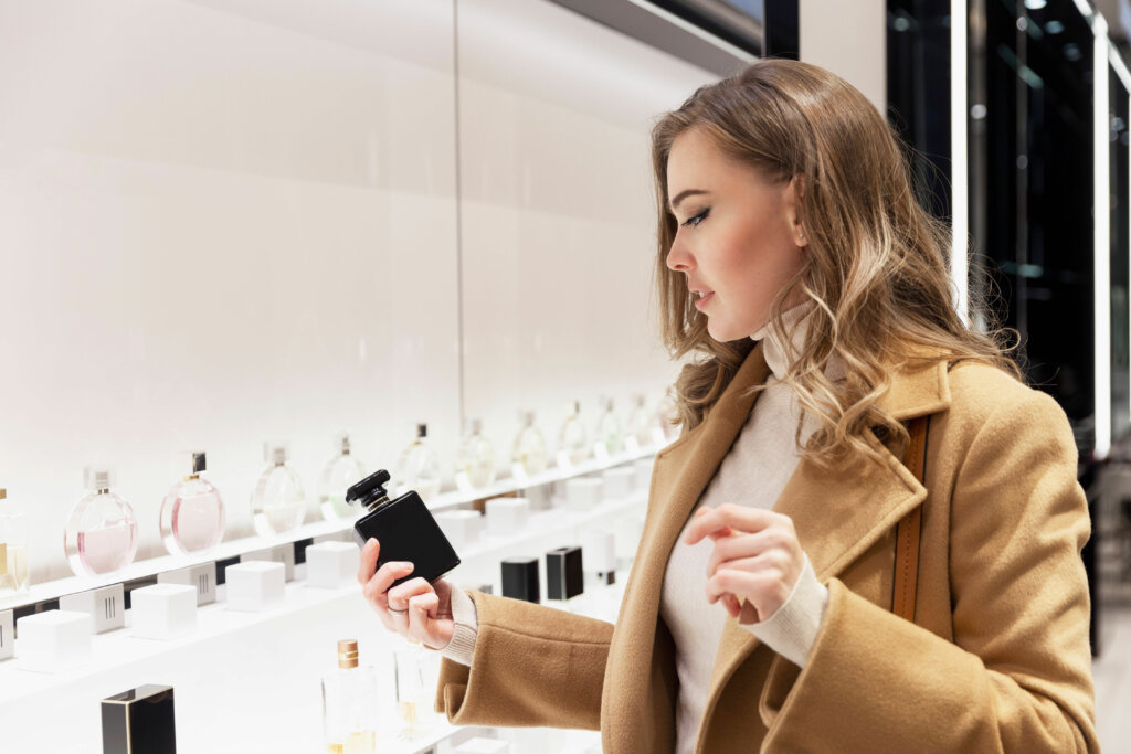 Mulher escolhendo perfume na prateleira