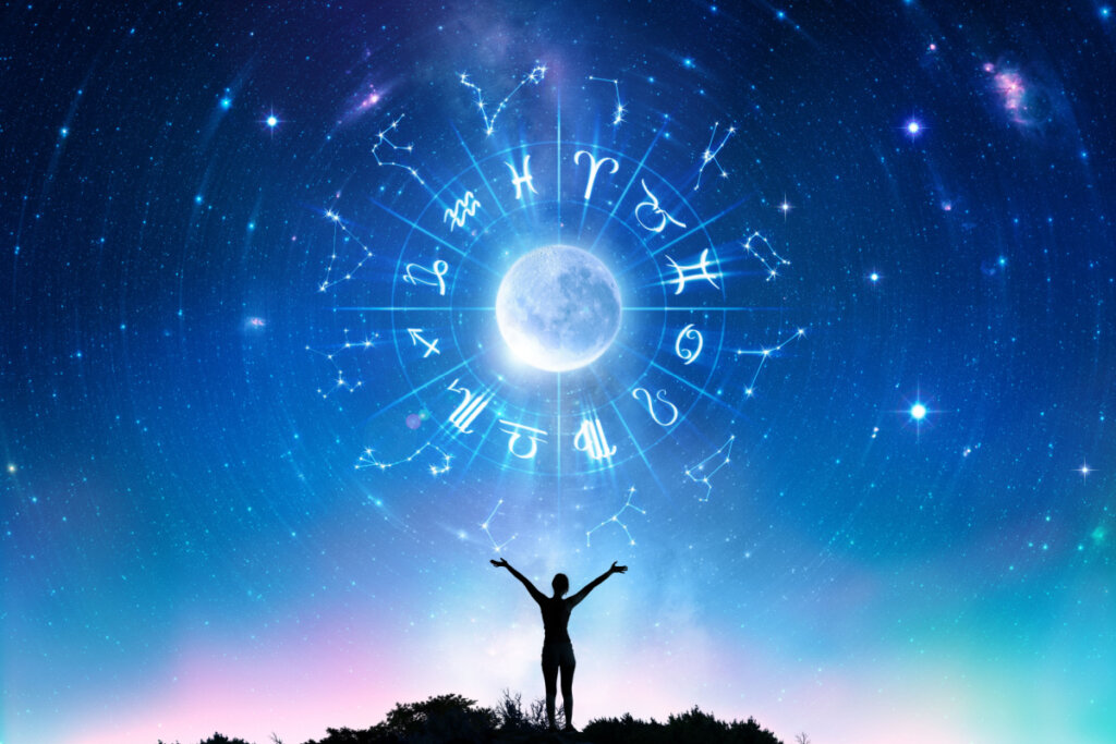 Imagem digital de uma mulher, com braços abertos e de frente para a Lua, a qual reflete os símbolos do zodíaco
