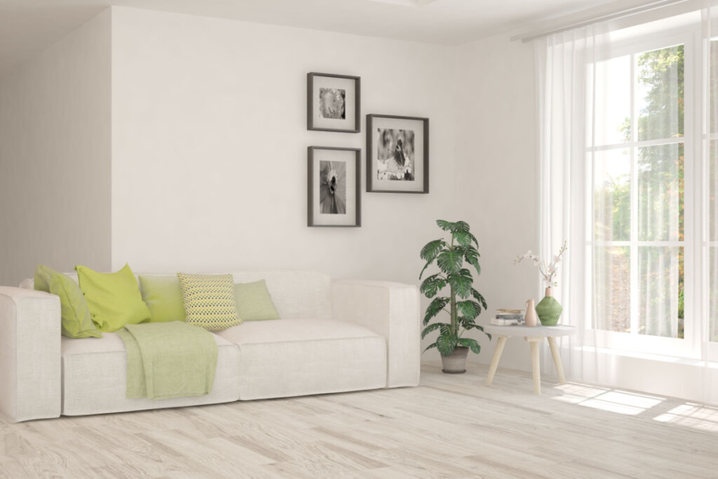 Sala de estar branca com sofá e paisagem de verão na janela