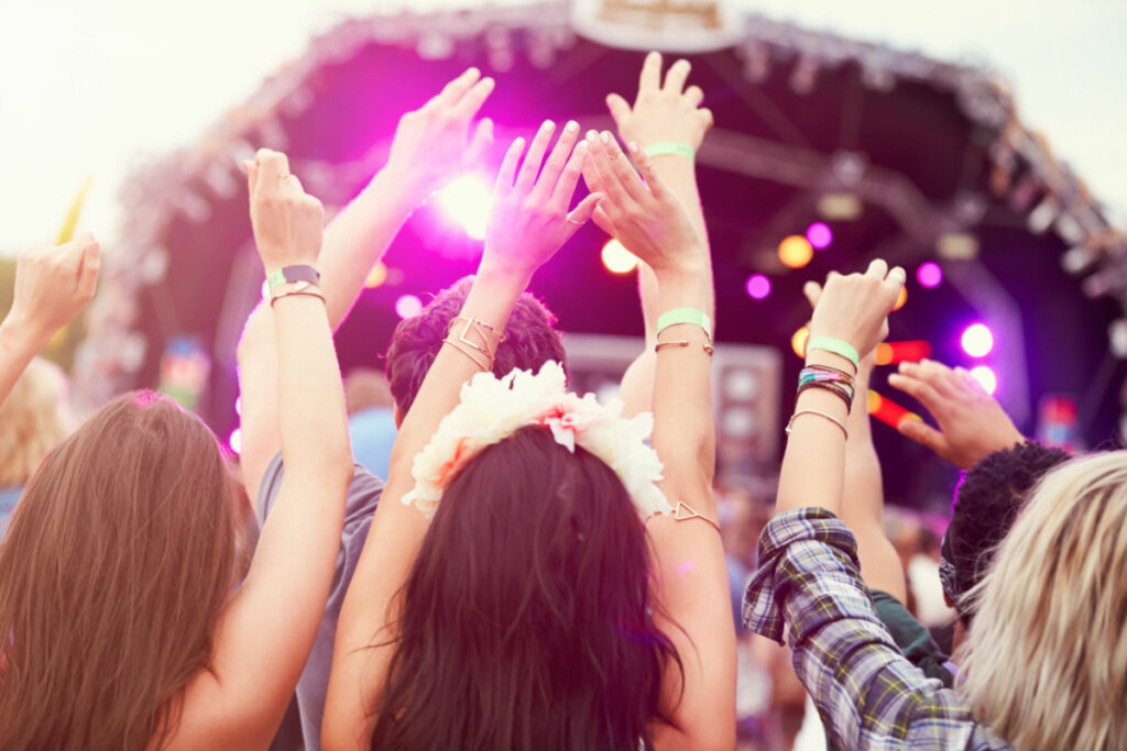 Público com as mãos no ar em um festival de música