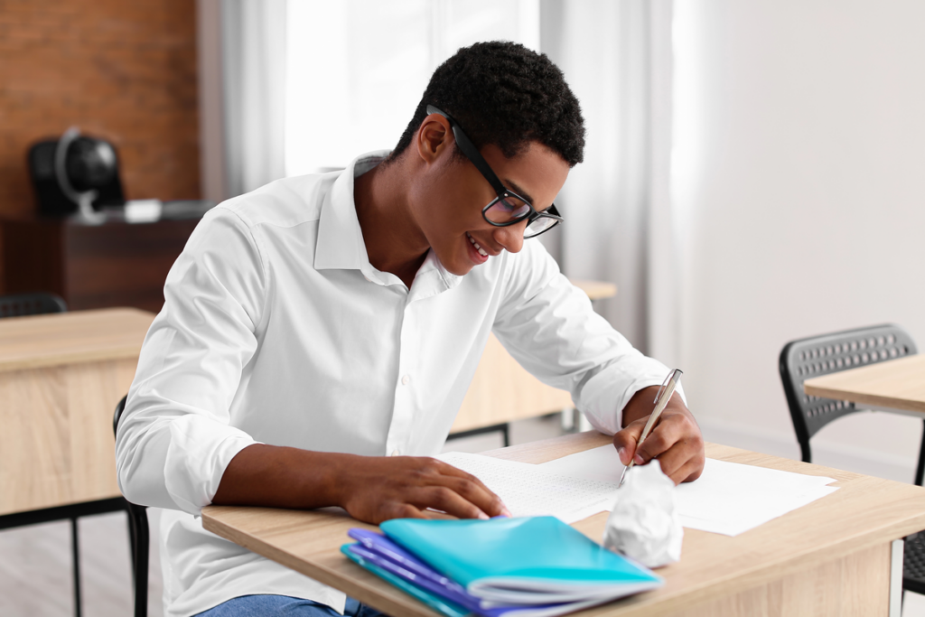 Menino sentando usando óculo e estudando 