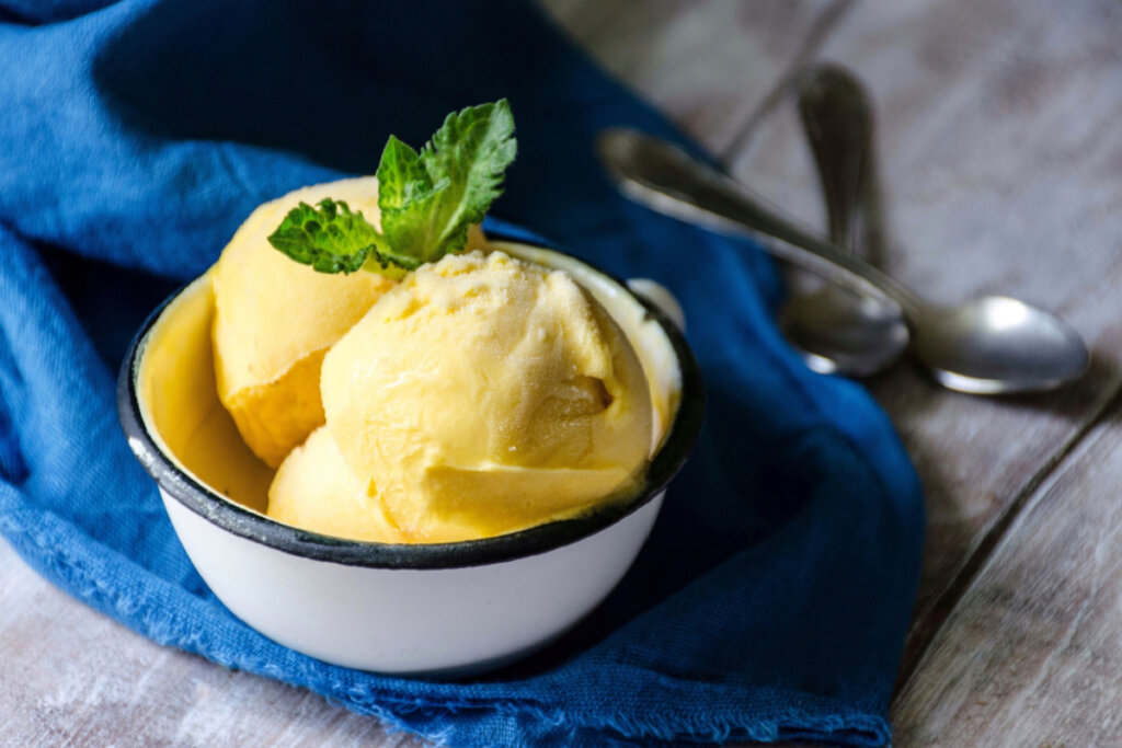 Três bolas de sorvete amarelo em pote branco 