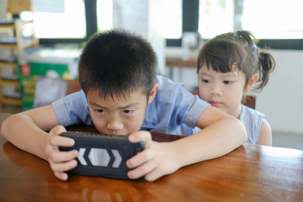 Crianças asiáticas assistindo ao tablet