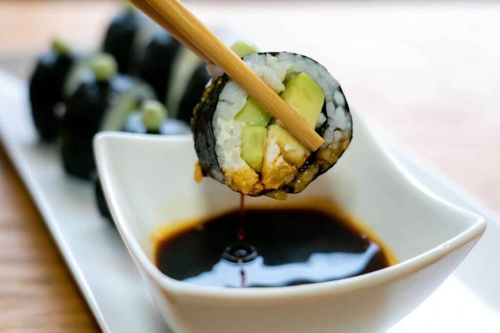 Sushi com abacate mergulhado em molho de soja