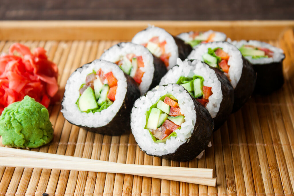 Sushis com pepino e tomate em cima de um tapete de bambu