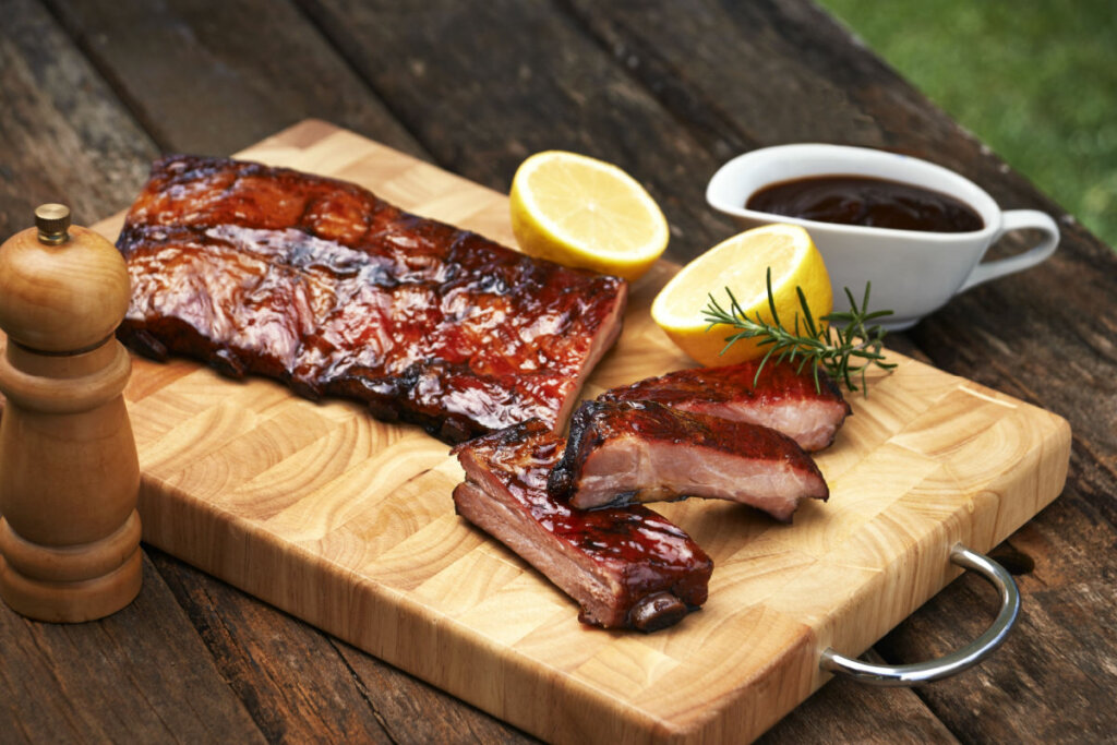 Costela de porco fatiada com barbacue e limão enfeitando