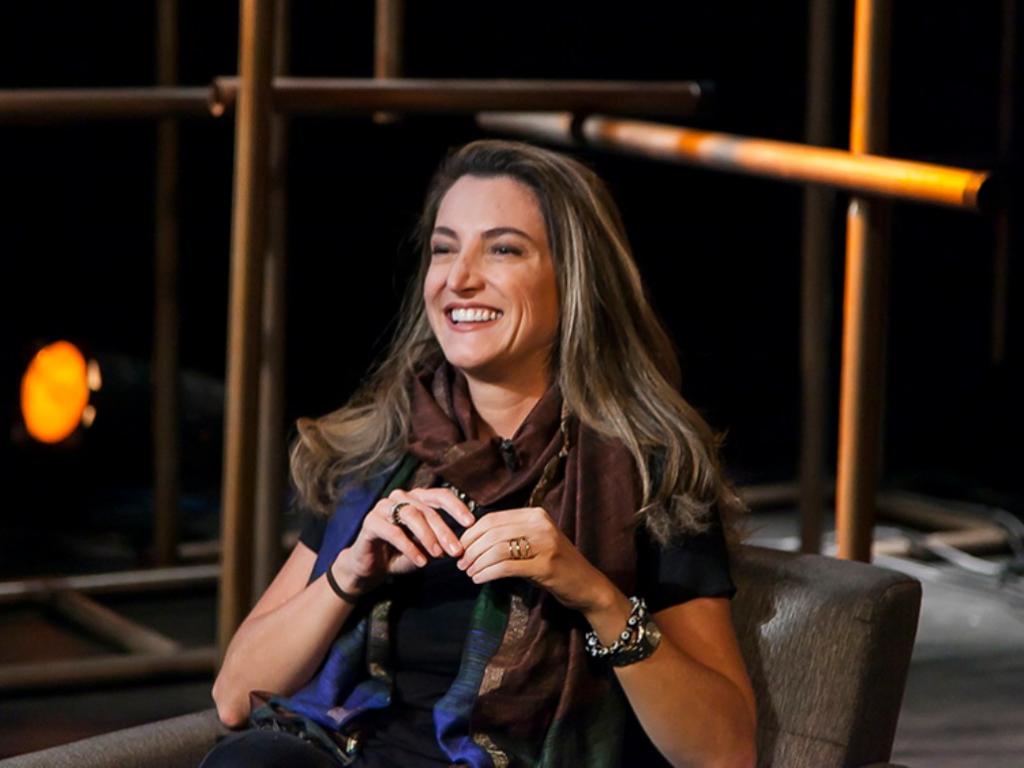 Jornalista Patrícia Campos Mello sentada sorrindo durante entrevista