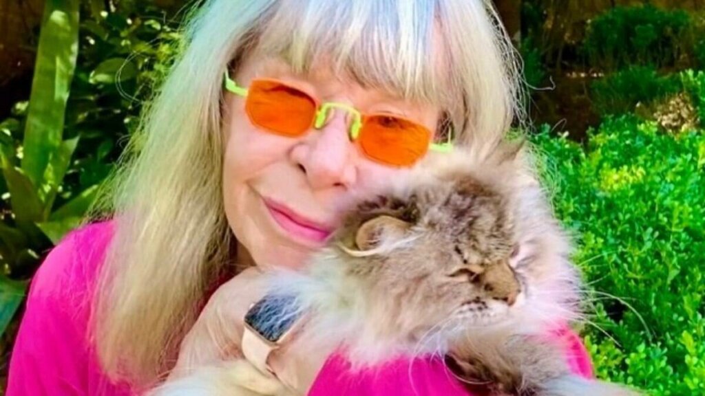 Rita Lee de óculos escuros segurando gatinho.