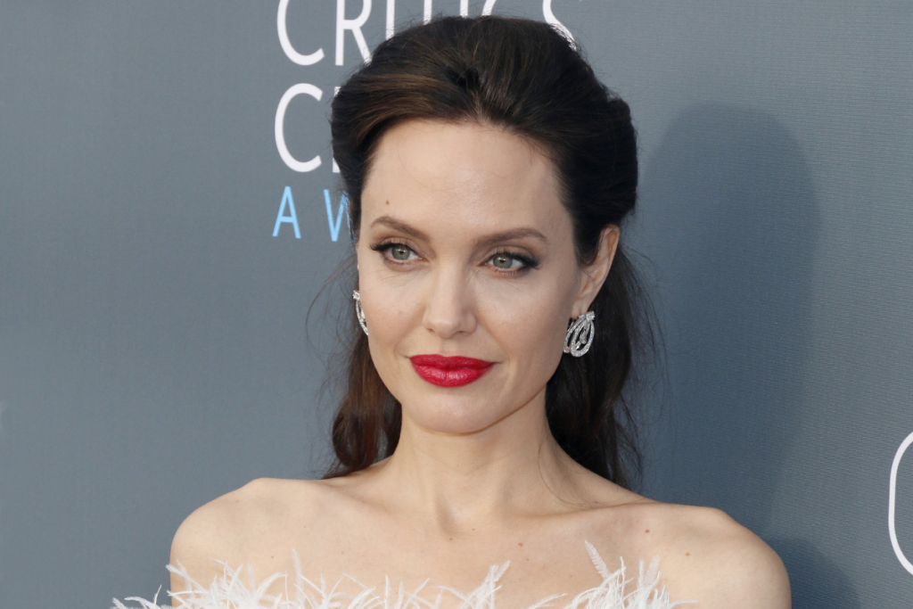 Angelina Jolie com cabelo preto e batom vermelho posando para foto 