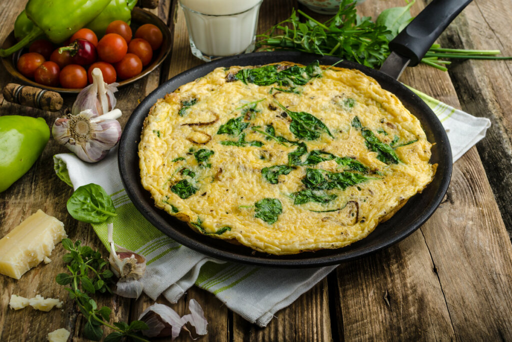 Frittata com espinafre em cima de uma frigideira preta