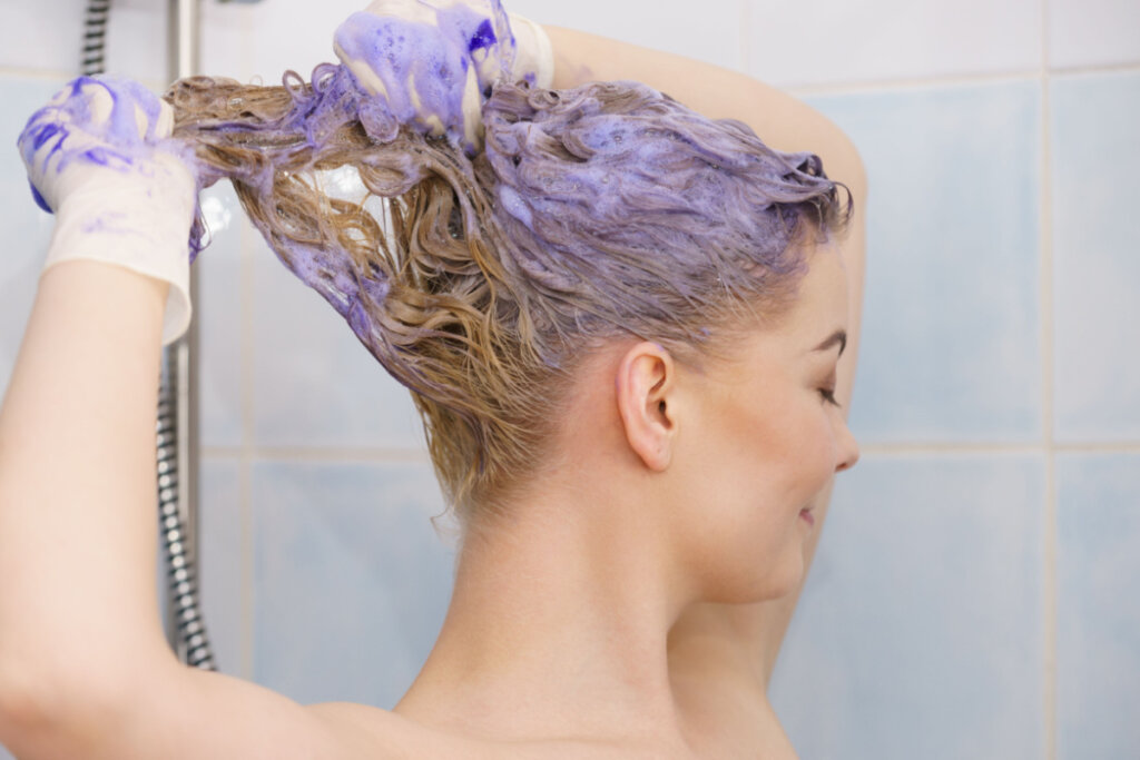 Mulher aplicando shampoo matizador no cabelo