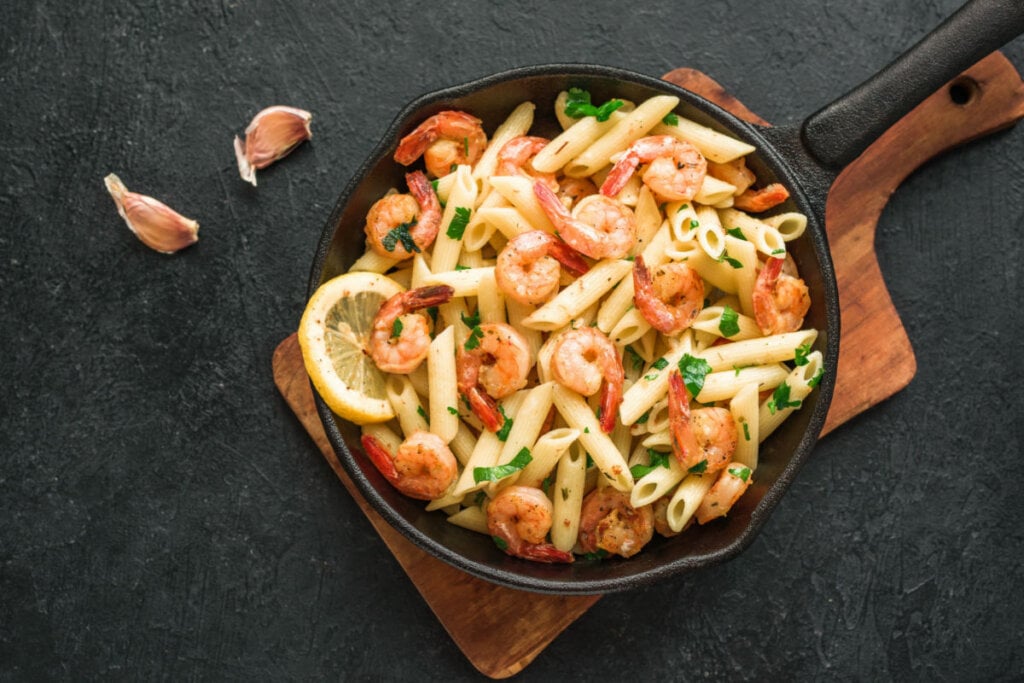 Penne com camarão e limão em uma frigideira preta