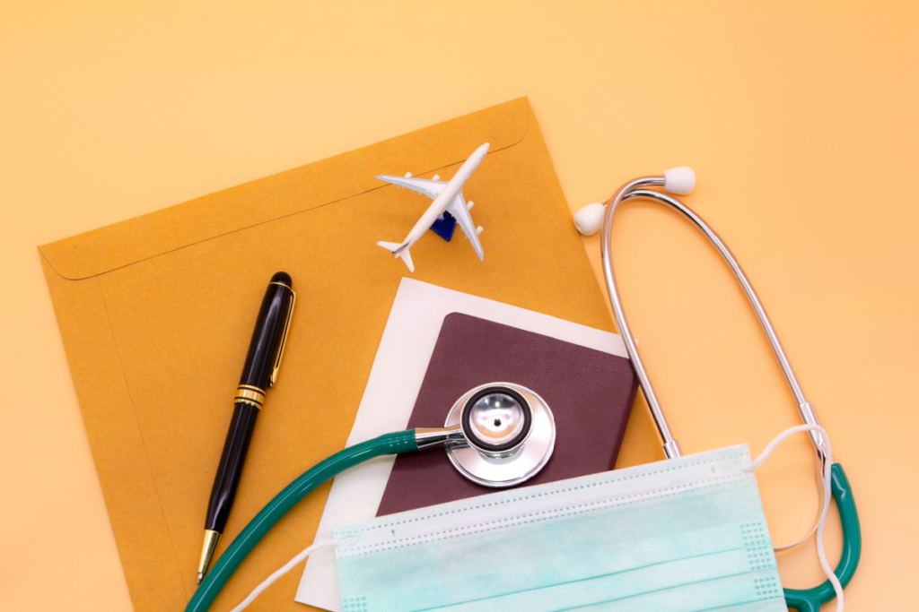 Conceito de seguro-viagem; caneta, passaporte, estetoscópio, máscara, envelope e ilustração de avião