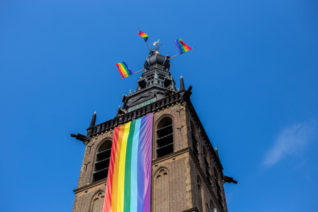 Bandeiras do arco-íris na frente e no topo da Igreja na Holanda.