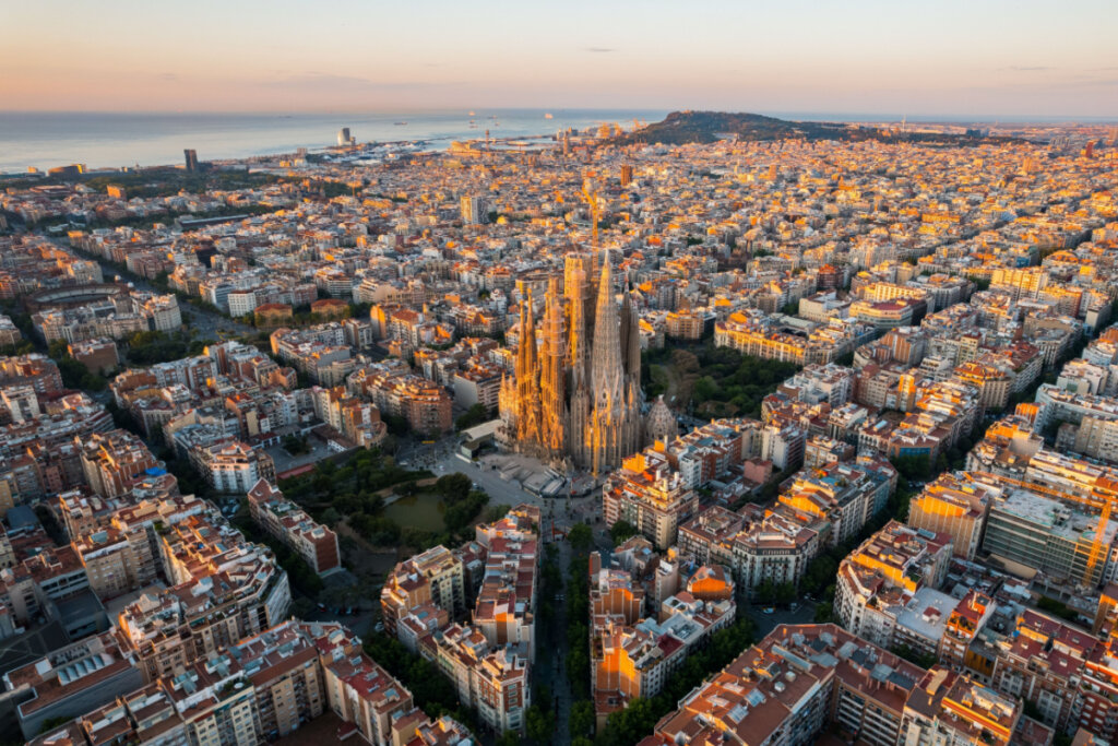 Visão aérea do distrito residencial Eixample de Barcelona e da Basílica da Sagrada Família ao amanhecer.