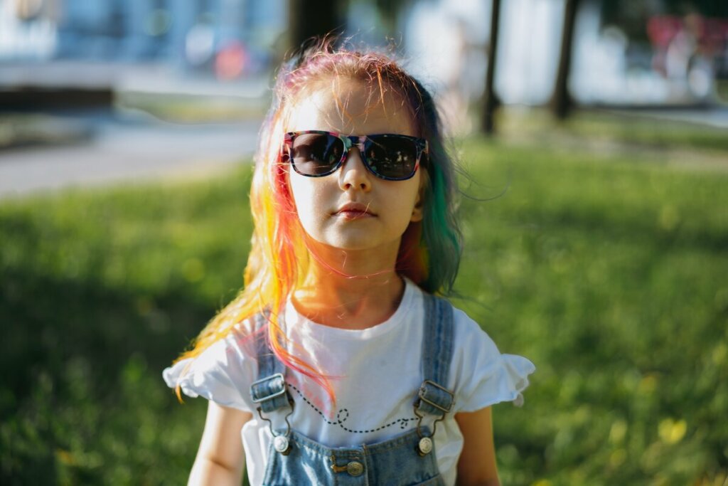 Menina de óculos de sol preto e cabelo colorido 