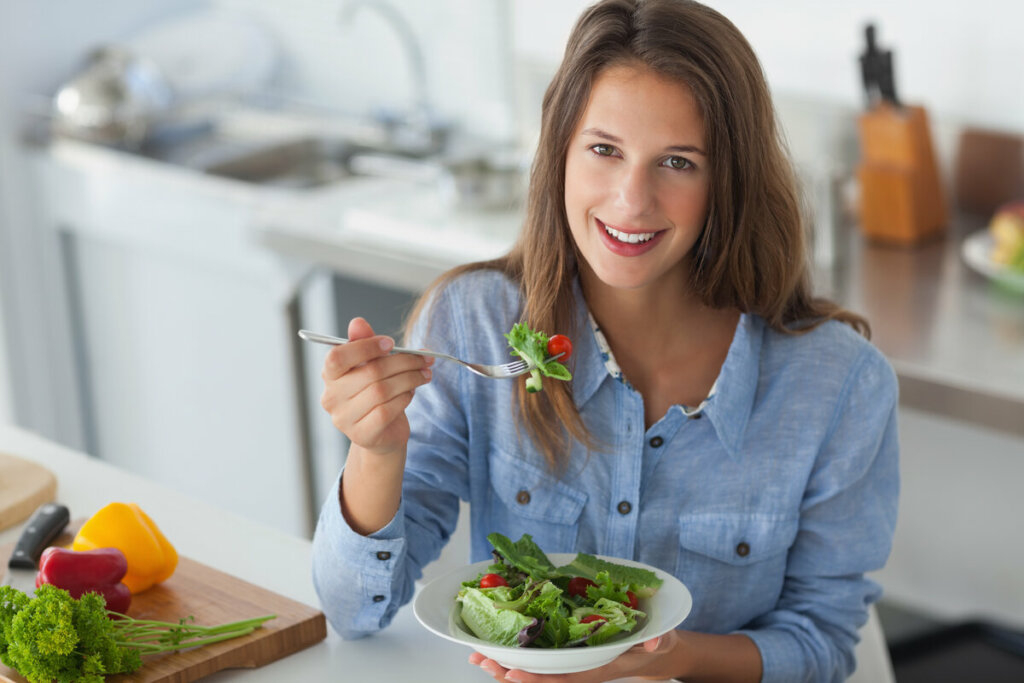 Mulher segurando um prato com salada 