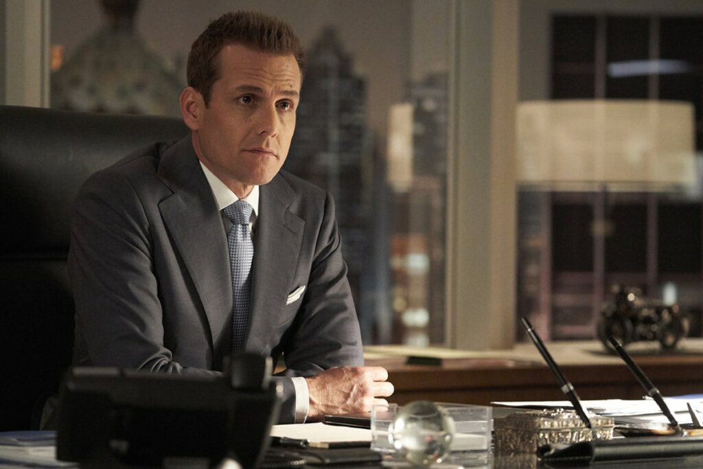 Cena da série Suits, em que o advogado Harvey está sentado de terno e com olhar sério.