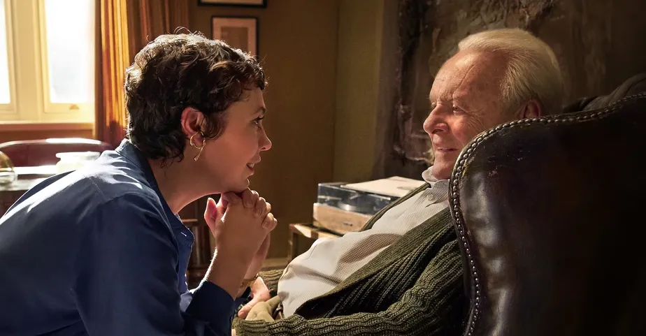 Cena do filme "Meu pai", mulher com a mão no queixo conversando com idoso em cadeira.