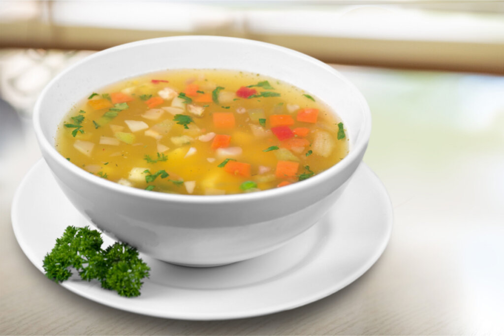 Sopa de legumes em vasilha branca