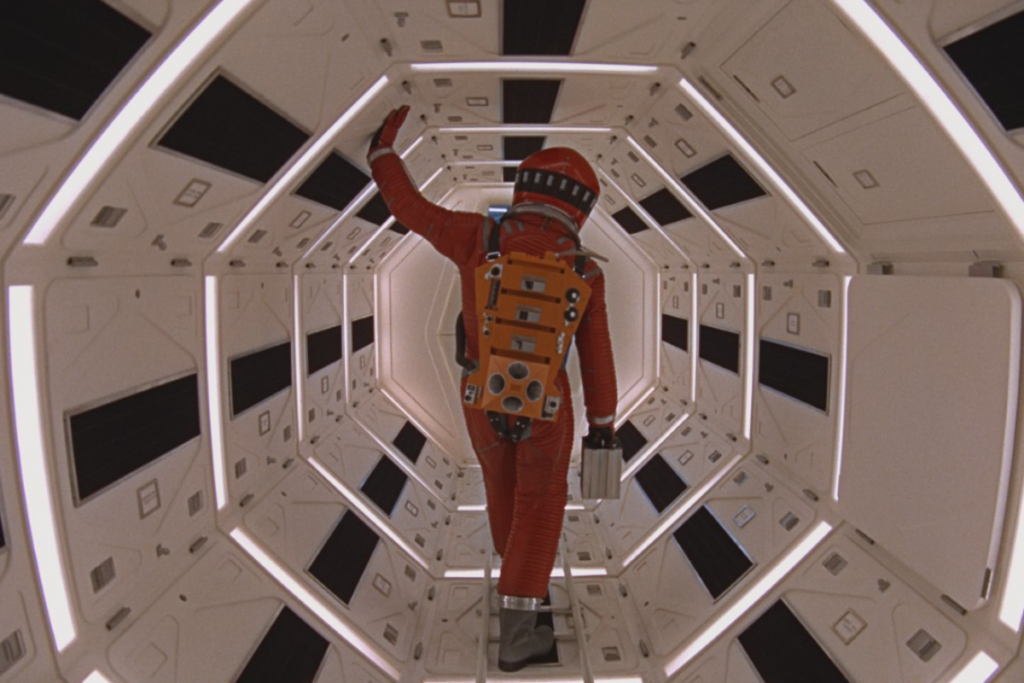 Personagem com traje espacial vermelho dentro de uma nave