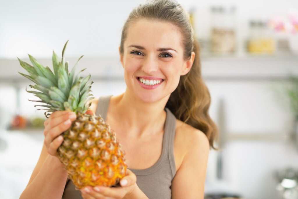 Mulher sorridente mostrando abacaxi