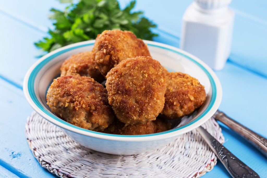 Recipiente azul e branco com bolinho de frango frito