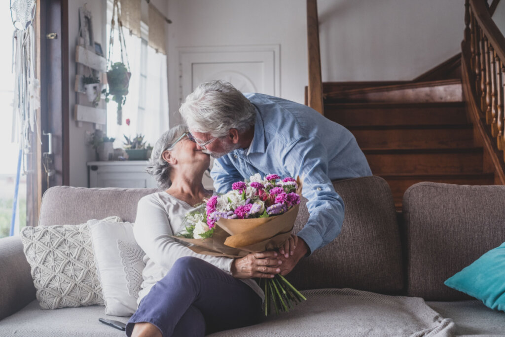 Homem idoso dando flores para sua esposa