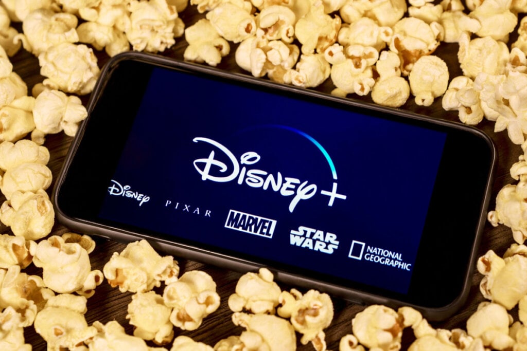 Celular com imagem da Disney+ com várias pipocas ao redor