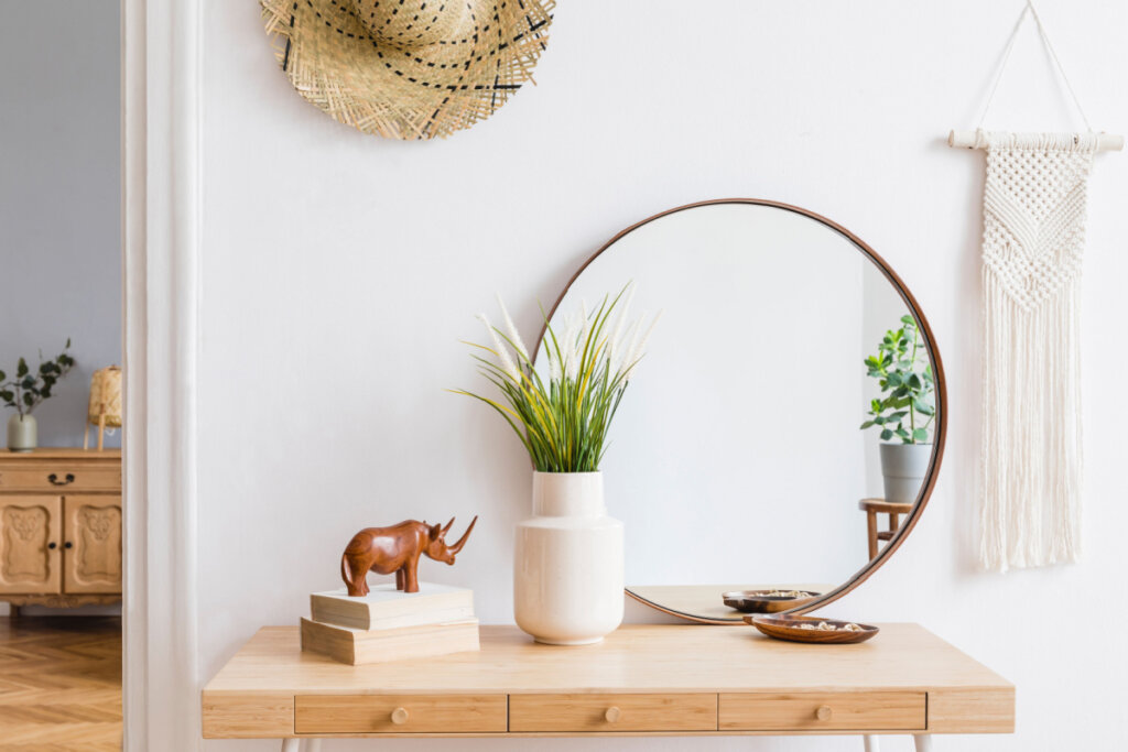 Mesa com objetos decorativos: espelho, vaso, rinoceronte e outros
