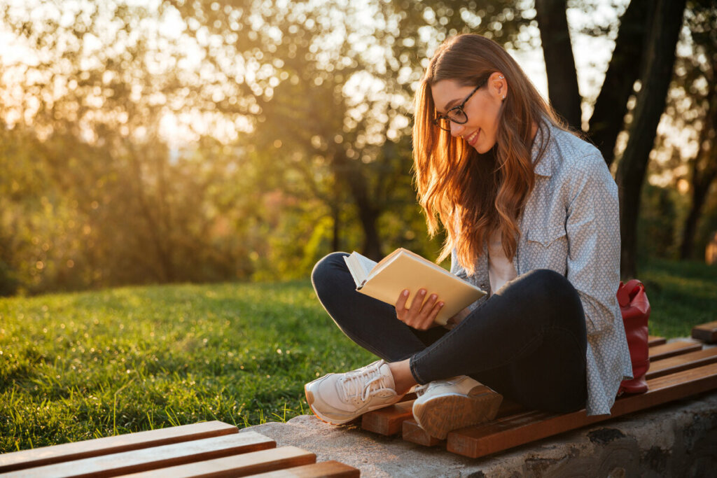 Mulher sentada em um parque lendo livro