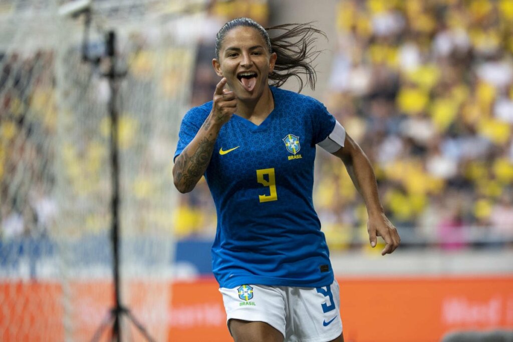 Debinha sorrindo durante jogo da seleção feminina atuando como goleira.