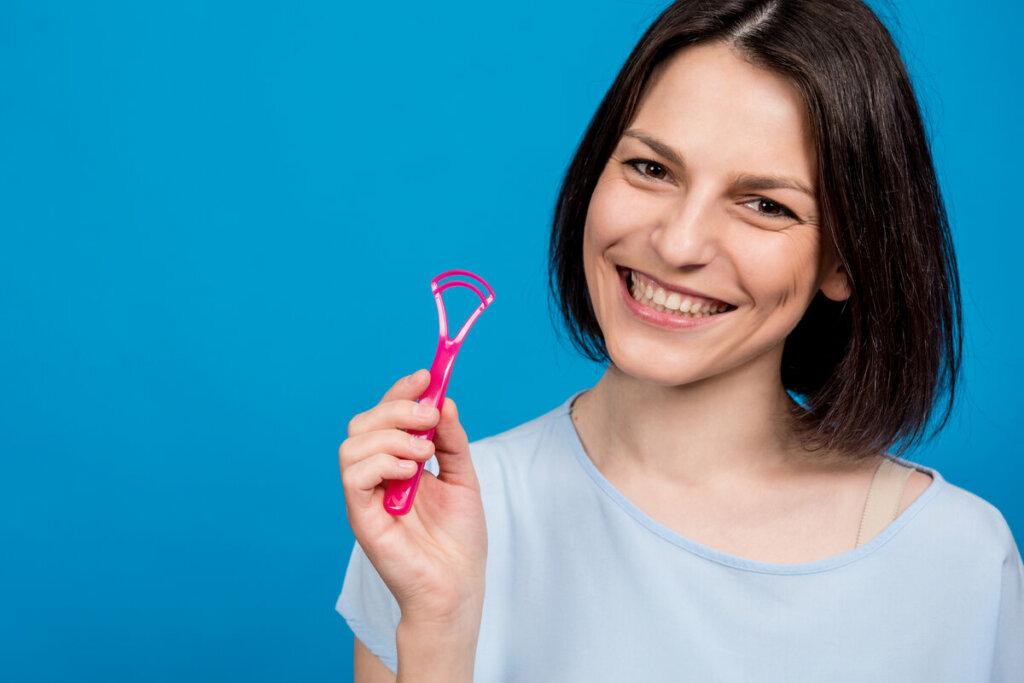Mulher sorrindo segurando uma escova de língua